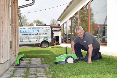 Günter Ströbel bei der Arbeit mit Rasenmäher